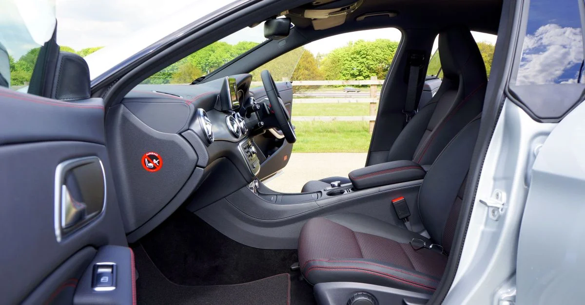Intérieur de voiture moderne de luxe avec un design épuré, des sièges en cuir et une technologie de tableau de bord avancée.