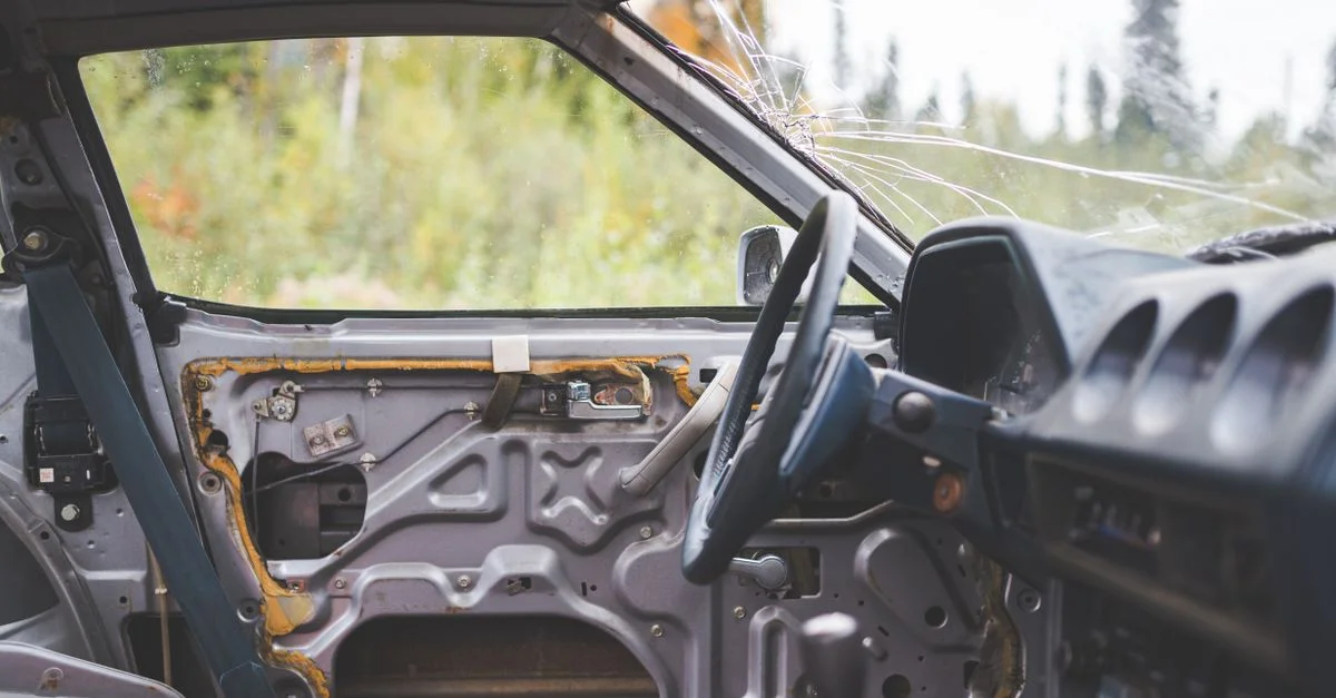 Découvrez l'intérieur négligé d'une voiture abandonnée, mettant en valeur des fenêtres brisées et des détails rustiques.
